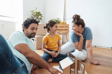 Glückliche Familie sitzt mit Modellhaus auf dem Boden - JOSEF21156