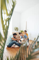 Familie prüft Modellhaus auf dem Boden zu Hause - JOSEF21159