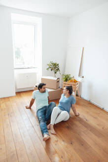 Couple talking and sitting on floor at home - JOSEF21160