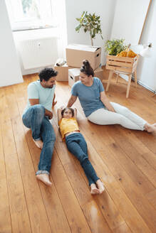 Glückliche Eltern mit Tochter, die zu Hause auf dem Boden liegt - JOSEF21170