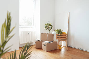 Cardboard boxes with wooden crate on table on floor at home - JOSEF21202