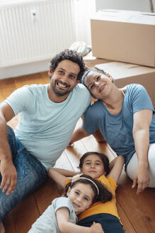 Happy parents with daughters lying on floor at home - JOSEF21245