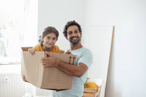 Glücklicher Mann mit Tochter, die zu Hause in einer Kiste sitzt - JOSEF21257