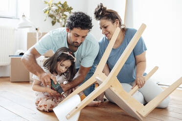 Mother with father and daughter fixing chair at home - JOSEF21277
