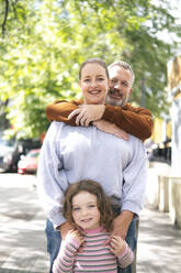 Happy family enjoying leisure time together at street - AMWF01810