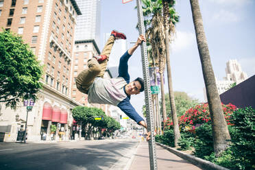 Parkour-Mann macht Kunststücke auf der Straße - Freier Läufer trainiert seinen akkratischen Hafen im Freien - DMDF06578