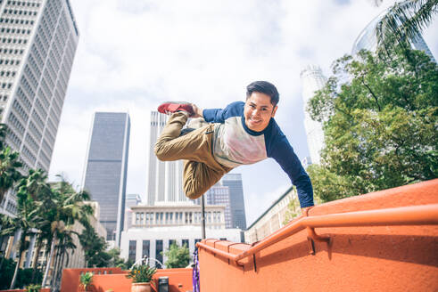 Parkour-Mann macht Kunststücke auf der Straße - Freier Läufer trainiert seinen akkratischen Hafen im Freien - DMDF06580