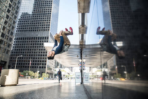 Parkour man doing tricks on the street - Free runner training his acrbatic port outdoors - DMDF06588