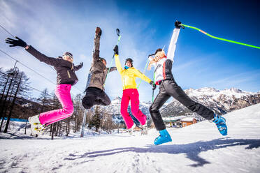 Eine fröhliche Gruppe von Freunden genießt ihren Winterurlaub beim Skifahren im Schnee - DMDF06597