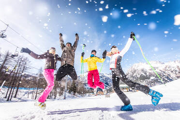 Eine fröhliche Gruppe von Freunden genießt ihren Winterurlaub beim Skifahren im Schnee - DMDF06598