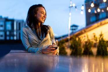 Storytelling footage of a multiethnic group of people dining on a rooftop. Family and friends make a reunion at home - DMDF06680