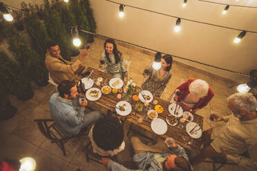 Erzählende Aufnahmen einer multiethnischen Gruppe von Menschen, die auf einer Dachterrasse speisen. Familie und Freunde treffen sich zu Hause - DMDF06683