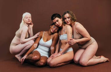 Eine Gruppe von Frauen unterschiedlicher Hautfarbe posiert gemeinsam im Studio und verkörpert das Konzept von Körperfreundlichkeit und Selbstakzeptanz - DMDF06707