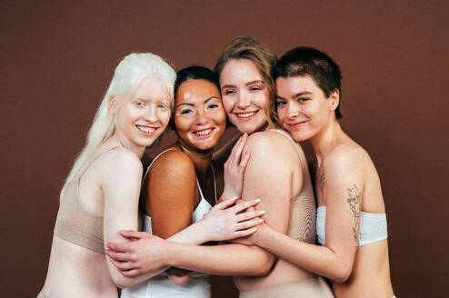 Eine Gruppe von Frauen verschiedener ethnischer Herkunft posiert gemeinsam im Studio und verkörpert das Konzept von Körperfreundlichkeit und Selbstakzeptanz - DMDF06711
