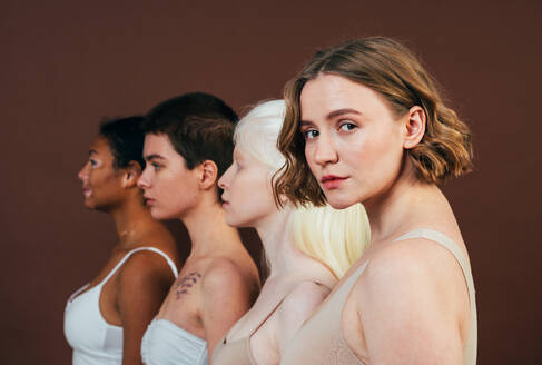 Group of multiethnic women with different kind of skin posing together in studio. Concept about body positivity and self acceptance - DMDF06725