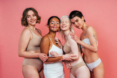 Eine Gruppe von Frauen mit unterschiedlicher Hautfarbe posiert gemeinsam im Studio, um Körperfreundlichkeit und Selbstakzeptanz zu fördern - DMDF06730