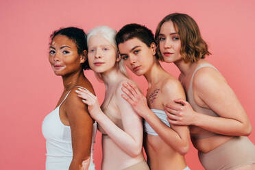 Eine Gruppe von Frauen unterschiedlicher Hautfarbe posiert gemeinsam im Studio und verkörpert das Konzept von Körperfreundlichkeit und Selbstakzeptanz - DMDF06738