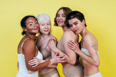 Eine Gruppe von Frauen unterschiedlicher Hautfarben posiert gemeinsam im Studio, um Körperfreundlichkeit und Selbstakzeptanz zu fördern. - DMDF06776