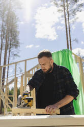 Ingenieur bei der Arbeit mit einem Gerät auf einem Brett auf der Baustelle - SEAF02022