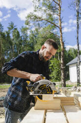 Engineer working with equipment on wood at construction site - SEAF02023