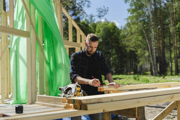 Ingenieur misst Holz auf der Baustelle - SEAF02025