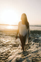 Frau geht am Strand im Wasser spazieren - SIF00976