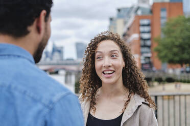 Happy woman talking with man in city - ASGF04641