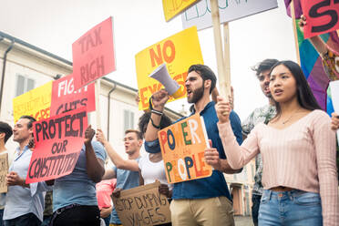 Group of activists is protesting outdoors - Crowd demonstrating against unemployment, taxes, wages dumping and other political and social issues - DMDF06860