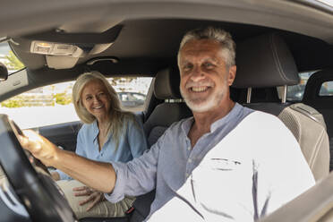 Happy couple sitting in car - JCCMF10798