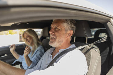 Mann und Frau genießen die Reise im Auto sitzend - JCCMF10799