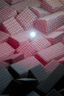 3D-Rendering einer leuchtenden Kugel über einem Haufen rosa Stofffliesen - GCAF00425