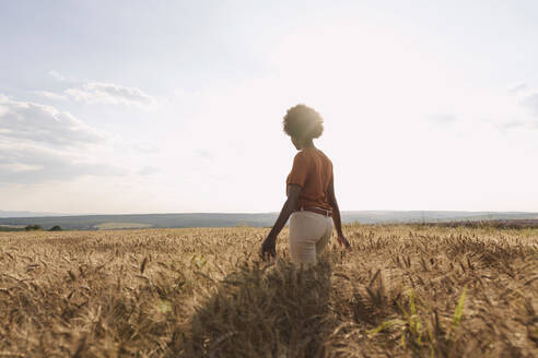 Young woman enjoying sunset at barley field - AAZF01185