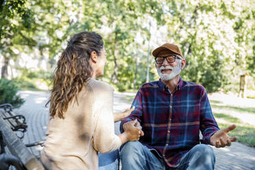 Happy retired senior man in wheelchair talking with caregiver - IKF01324