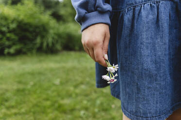 Girl holding flowers in garden - EYAF02850