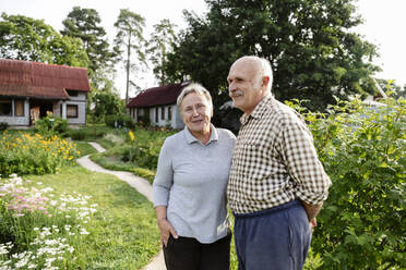 Glückliches älteres Paar im Garten stehend - EYAF02853