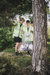 Junge sammeln Müll in einer Plastiktüte auf - MASF39641