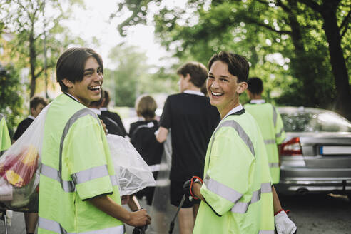 Portrait of happy boys wearing reflective clothing walking together - MASF39652