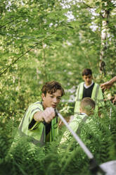 Jugendlicher sammelt Plastikmüll aus Grünflächen auf - MASF39674