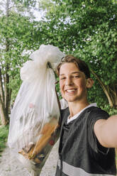 Porträt eines glücklichen Teenagers mit Müllsack - MASF39700
