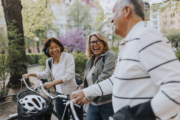 Fröhliche Senioren genießen gemeinsam eine Fahrradtour im Park - MASF39738