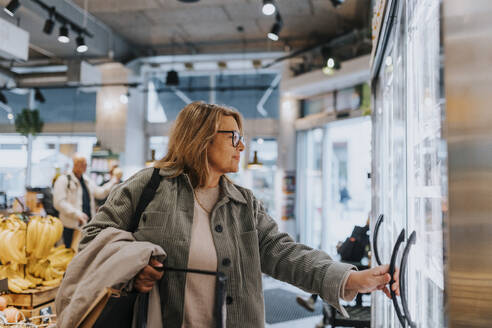 Smiling senior woman doing shopping in supermarket - MASF39775