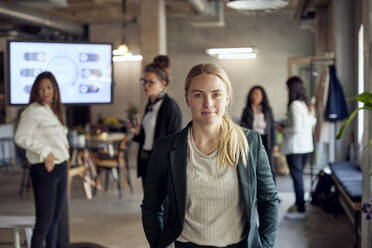 Portrait of blond businesswoman standing standing at creative office - MASF39864