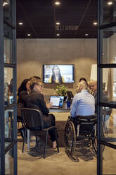 Businessmen and businesswomen discussing during video conference in board room at office - MASF39892