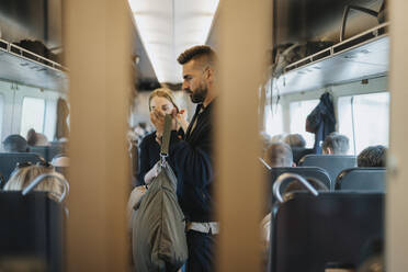 Man holding luggage while traveling in train with family - MASF39999