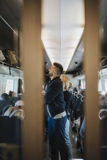 Man loading luggage while standing in train - MASF40004