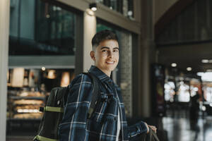 Side view of smiling boy wearing plaid shirt at station - MASF40026