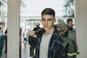 Porträt eines Teenagers mit Gepäck am Bahnhof - MASF40029