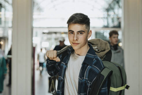 Porträt eines Teenagers mit Gepäck am Bahnhof - MASF40029