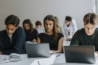 Multirassische Teenager lernen am Schreibtisch im Klassenzimmer - MASF40144