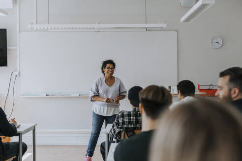 Lächelnder Lehrer unterrichtet im Klassenzimmer - MASF40148